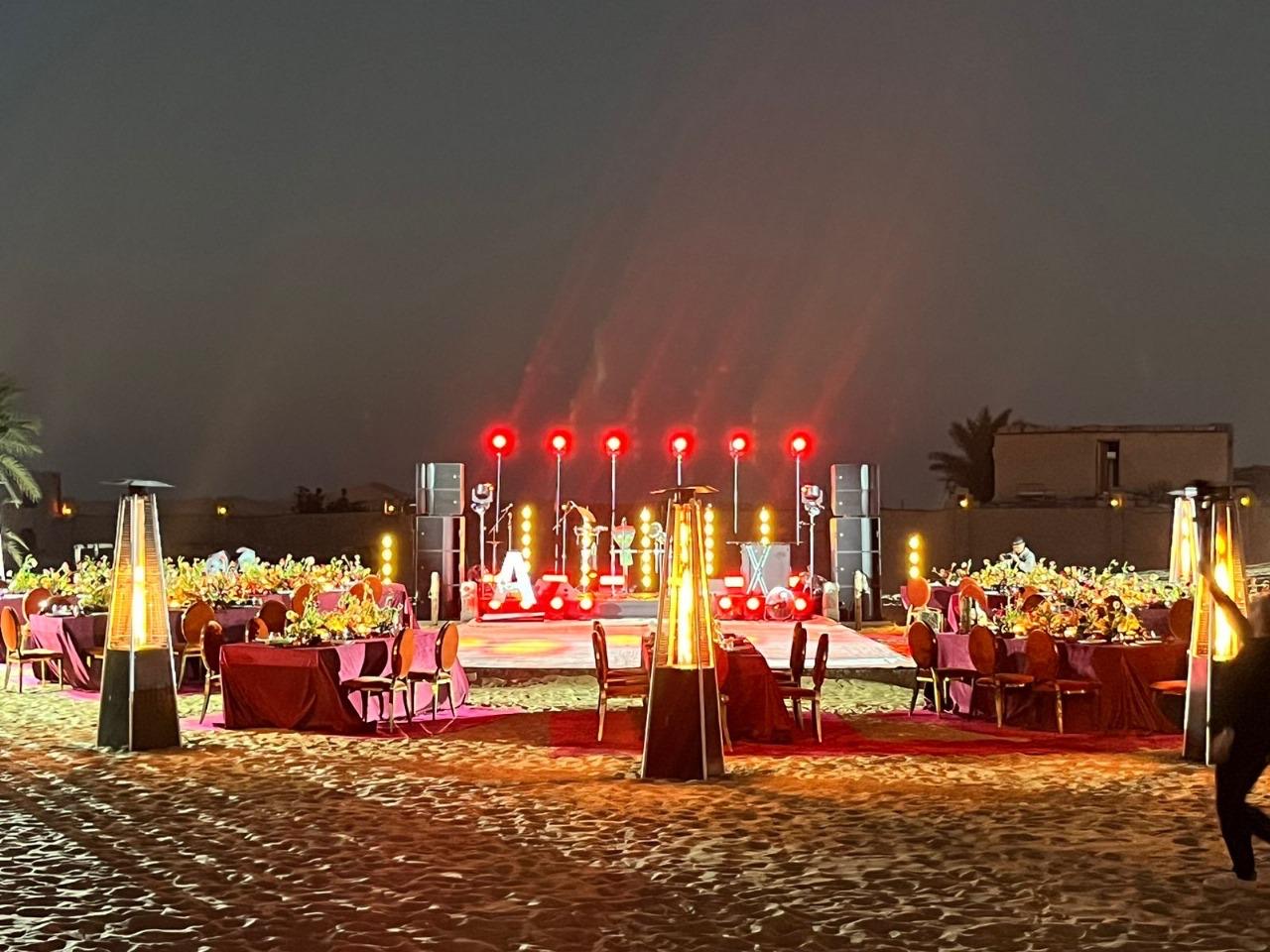Evening stage and dining setup at a desert gala dinner near Abu Dhabi